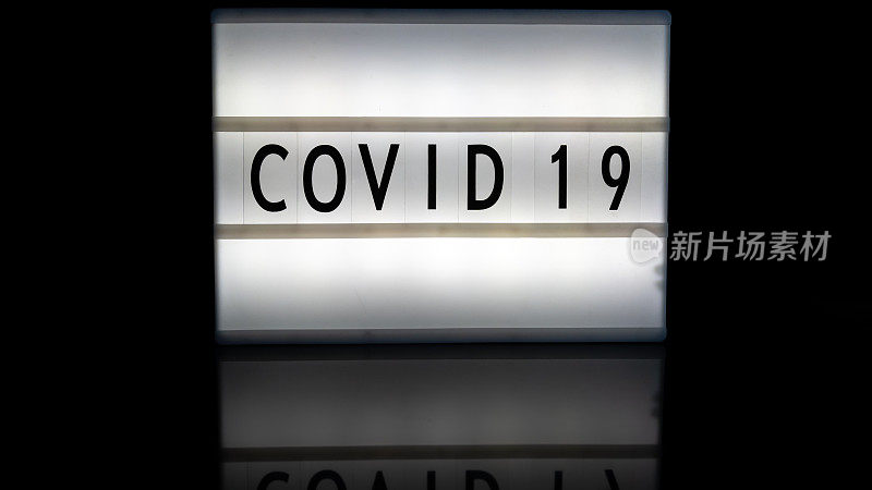 灯箱反光表面上的Covid 19字母